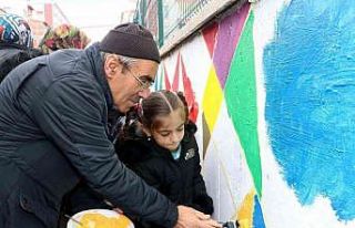 Dedelerinin yardımıyla okul duvarlarını boyadılar