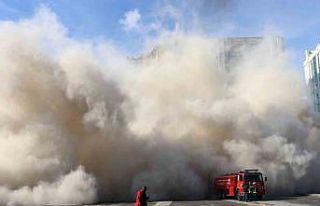 Depremde ağır hasar gören bina yıkılıyor, toz...