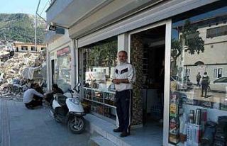 Hatay’da bir esnaf, yıkılan binaların arasında...