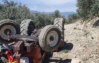Devrilen traktörün altından yardım istedi