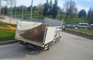 Kasa arka kapağı açık kamyon yükünü döke döke...