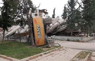 Hasarlı bina yıkımı esnasında iş makinesi devrildi