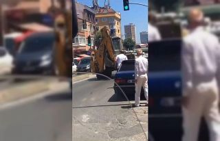 İş makinası operatörü trafikte otomobile kepçe...