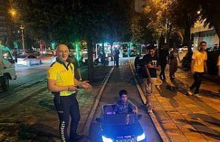 Akülü arabasıyla kaldırımda giden çocuk ile...