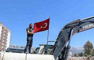 Enkazdan çıkardığı Türk bayrağını iş makinesinde...
