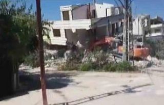 Binanın yıkım esnasında iş makinasının üzerine...