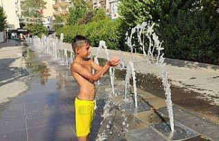 Cizre’de sıcaklardan bunalan çocuklar su fıskiyesinin...
