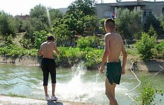 Sıcak bunaltınca yüzmesi yasak olan kanalda serinlediler