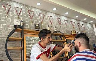 Milli maç heyecanıyla müşterilerini traş ediyor