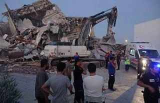 Yıkım sırasında bina iş makinasının üzerine...