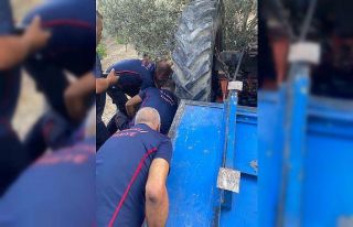 Devrilen traktörün altında kalan sürücüyü kurtarmak...