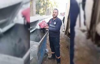 Temizlik işçisi yanmak üzere olan bayrağı çöpten...