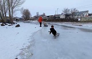 Buz tutan derede kızakla kayıp gönüllerince eğlendiler