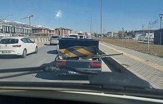 Karayolu işaret levhasını otomobil ile taşıdı
