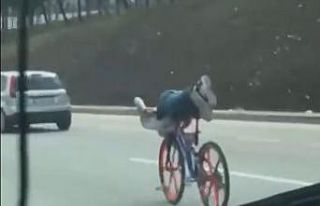 Bisikletin üzerinde uzanarak giden gençler trafiği...