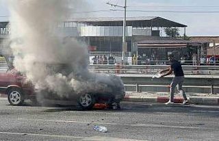 Alev alan otomobilini kendi çabasıyla söndürmeye...