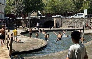 Sıcak havada kavrulan çocuklar, süs havuzunda serinliyor