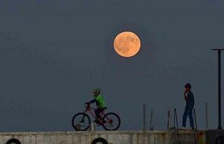 Dolunay ile insanların siluetleri aynı karede
