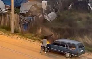 Alev alev yanan aracını kovayla su döküp söndürdü