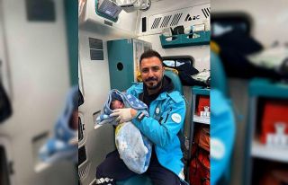 Ambulansta doğum yapan anne bebeğine sağlık personelinin...