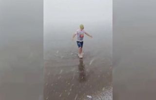 Kar altında denize girip yüzdü attı