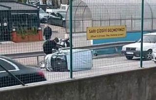 Rüzgarın etkisiyle devrilen otomobile çevredeki...