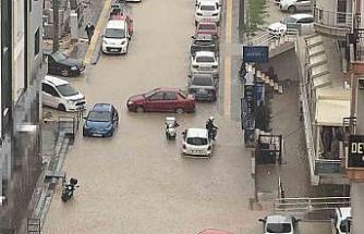 Yağmurda mahsur kalan motosikletli çareyi otomobilin üzerine çıkmakta buldu